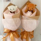 Two small teddy bear bouquets with pink roses, tied with gold ribbon.