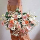 Basket of pink and peach roses, gerbera daisies, and baby's breath.