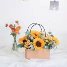 Basket of sunflowers and yellow daisies with eucalyptus.