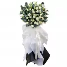Funeral wreath with white roses, lilies, and eucalyptus.