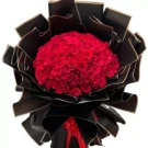 Large bouquet of 150 red roses, wrapped in black paper with a red ribbon.