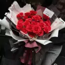 Bouquet of red roses with a "Happy Day" card and pearl accents.