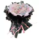 A large bouquet of rainbow-colored baby's breath flowers in black and pink wrapping.