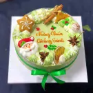 Green Christmas mousse cake with Santa, gingerbread star, orange, cinnamon, and "Merry Christmas" text.