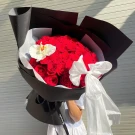 Bouquet of 50 red roses with a white orchid and a white ribbon, elegantly wrapped in black paper.