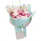 Pink and white flowers in a bouquet wrapped in light blue paper with a pale pink ribbon.