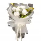 White peonies and greenery in a bouquet with white sheer wrapping and ribbon.