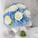 White roses with blue hydrangeas on a white satin ribbon.