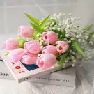 Pink tulips and baby's breath on books.