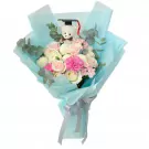 Bouquet of pink and white roses, carnations, and chrysanthemums with a teddy bear wearing a graduation cap.