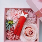 MAC 95 Vicious liquid lipstick in a pink gift box surrounded by faux flowers.
