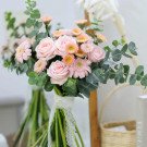 Bouquet of pink roses, yellow gerbera daisies, and eucalyptus.