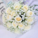 Creamy white roses and baby's breath in a bridal bouquet.