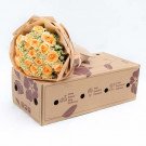 Peach roses and daisies in brown paper bouquet on a cardboard box.
