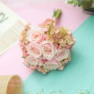 Pink roses and hydrangeas in a bridal bouquet with a satin ribbon.