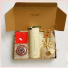 Gift box with thermal flask, handmade candle, small pouch, and card.