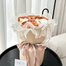 Peach roses and white orchids arranged in a gift bouquet with sheer ribbon and a "Happy Day" card.