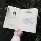 Open book with illustration of a person hugging themselves.