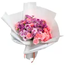 Bouquet of pink and purple chrysanthemums and carnations wrapped in white paper.