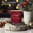 Red Christmas candle labeled "First Snowfall" with snowflake and village designs.