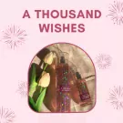 Bath & Body Works A Thousand Wishes body mist bottles with tulips on a pink background.