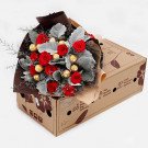 Bouquet of red roses and Ferrero Rocher chocolates in a box.