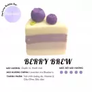 A slice of layered soap cake with blueberries on top, labeled "Berry Brew".