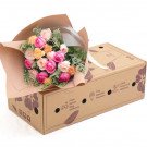 Bouquet of pink and orange roses with a cardboard box.