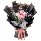 Pink roses in black paper with pink ribbon.