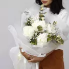 White peony bouquet with eucalyptus and baby's breath, wrapped in white mesh.
