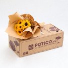 A bouquet of sunflowers wrapped in brown paper sits on a cardboard box.