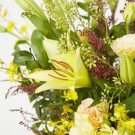 Yellow lilies and delicate greenery create a fresh, bright floral arrangement.