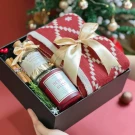 Christmas gift box with red blanket, candle, and diffuser.