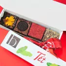 Brownies with Oreo, red sprinkles, and nuts in a Tet gift box with a red scarf.