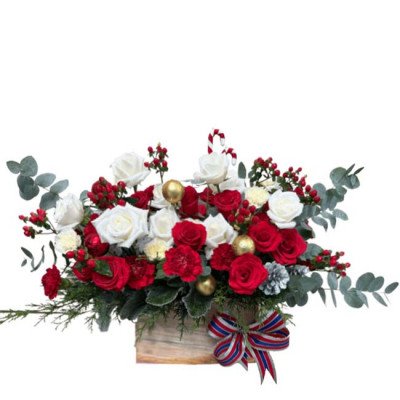 Red and white roses and carnations in a wooden box with festive decorations.