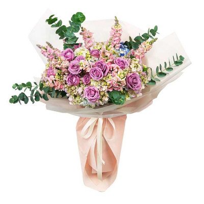 Pastel bouquet of pink roses, hydrangeas, snapdragons, and eucalyptus, wrapped in light pink paper.