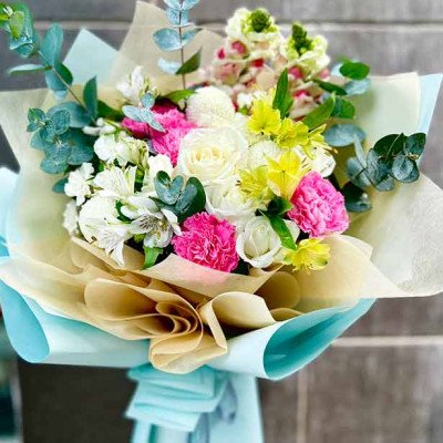 Bouquet with white roses, pink and white carnations, yellow flowers, and eucalyptus.