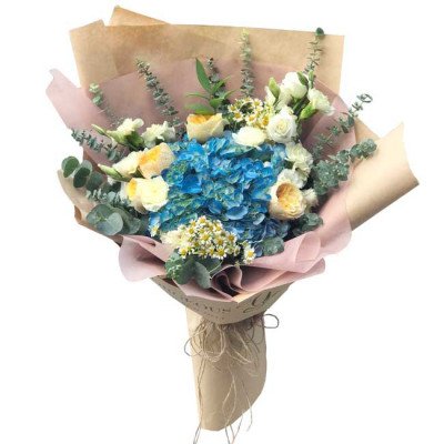 Bouquet of blue hydrangeas, yellow roses, white flowers, and eucalyptus in kraft paper.