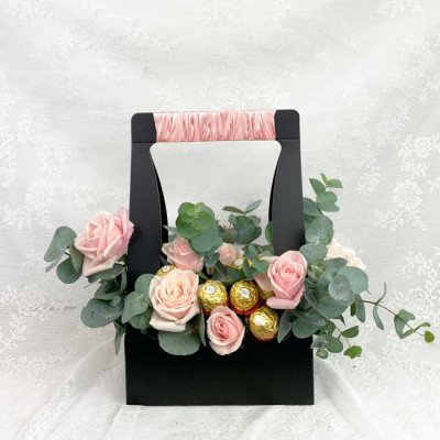 Black basket with pink roses and Ferrero Rocher chocolates.