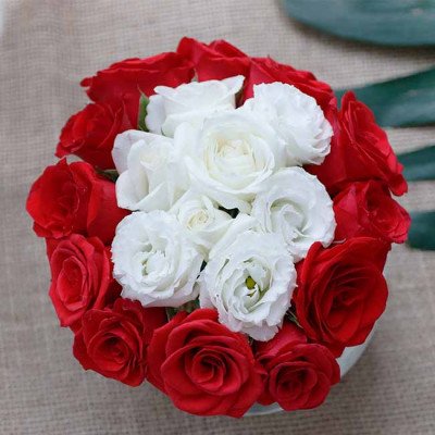 Red and white roses arranged in a bouquet with a burlap background.