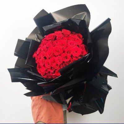 A large bouquet of 150 red roses wrapped in black paper.