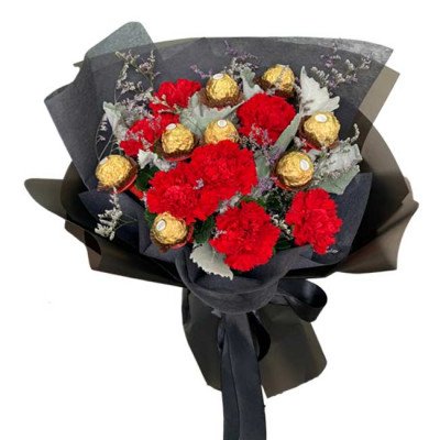Bouquet of red carnations and Ferrero Rocher chocolates in black wrapping.