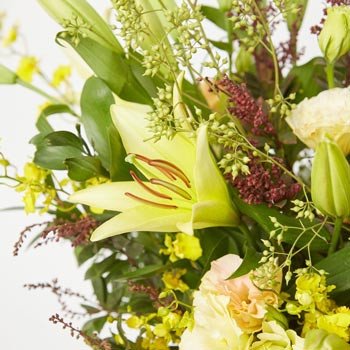 Yellow lilies and delicate greenery create a fresh, bright floral arrangement.