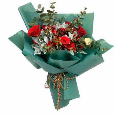 A bouquet of red roses, red carnations, pine cones, and eucalyptus wrapped in teal paper and tied with a festive ribbon.