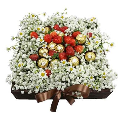 Strawberries and chocolates arranged with white flowers in a wooden box tied with a brown ribbon.