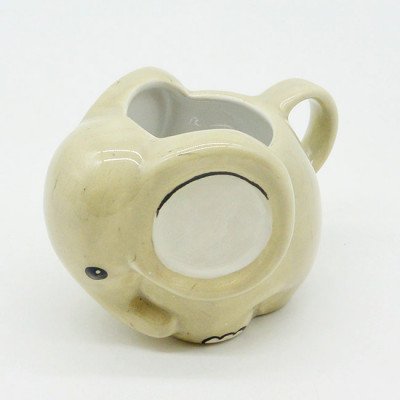 Cute beige ceramic elephant mug with a handle and a rounded body.