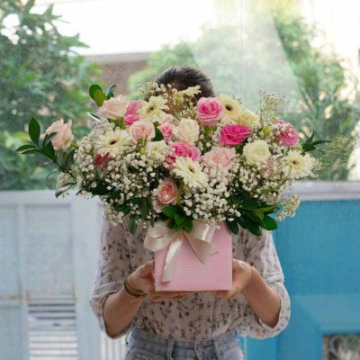 Pink box arrangement of roses, gerbera daisies, and baby's breath.