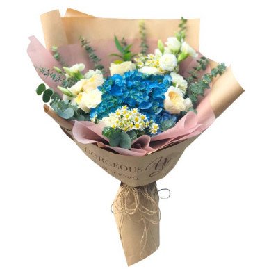 Blue hydrangea, white roses, and daisies bouquet in brown paper wrap with twine.