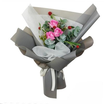 Pink roses and eucalyptus in grey and white floral wrap, tied with a white ribbon.