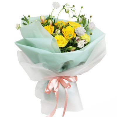 Bouquet of yellow roses and white flowers wrapped in mint green paper with a pink bow.
